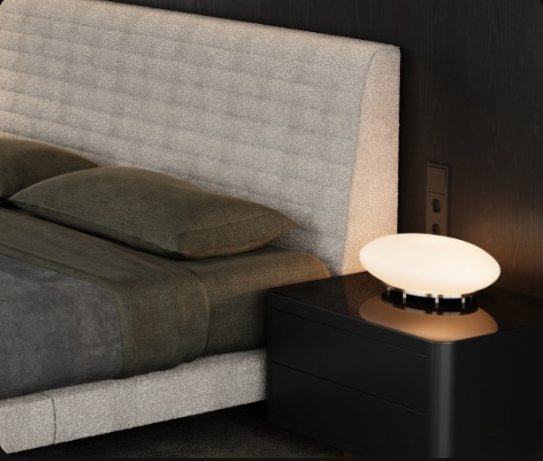 Close-up render of an upholstered headboard and a glowing bedside lamp